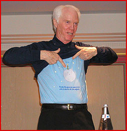 Rusty Schweickart shows off a T-shirt with Le Petit Prince on asteroid B612